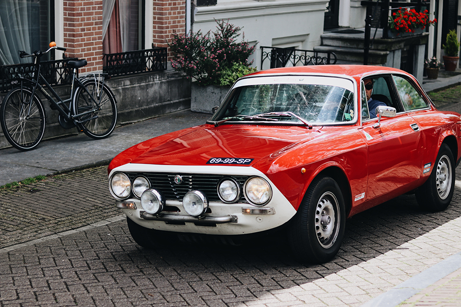 a vintage red and white car being driven